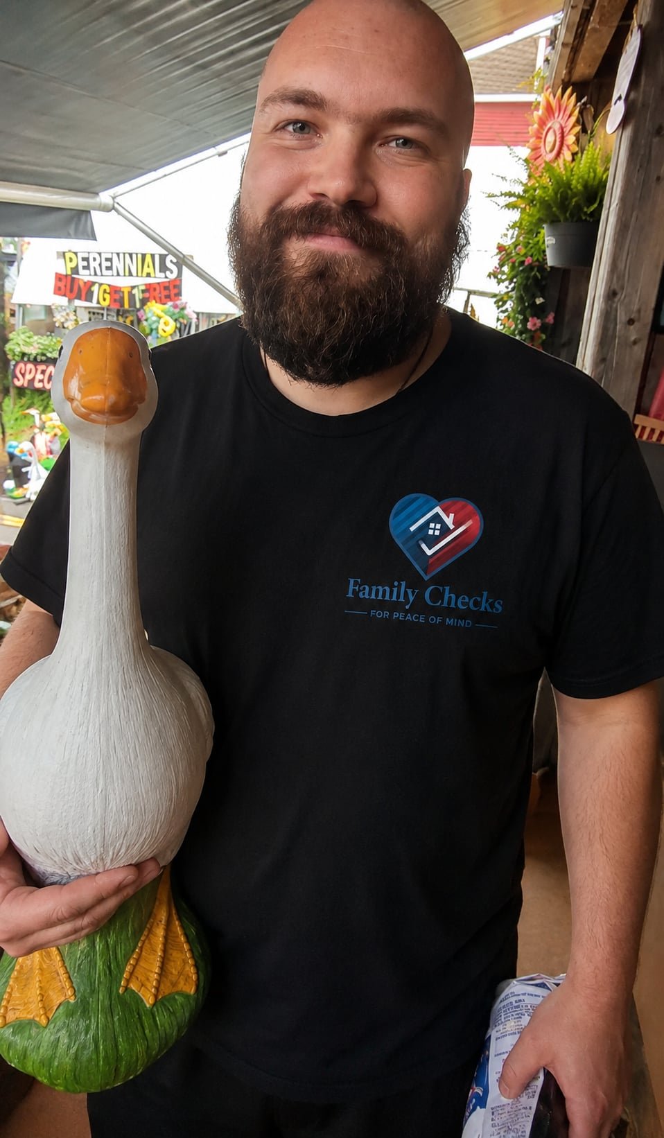 Jeremy, a Family Checks support team member, standing beside a decorative goose.